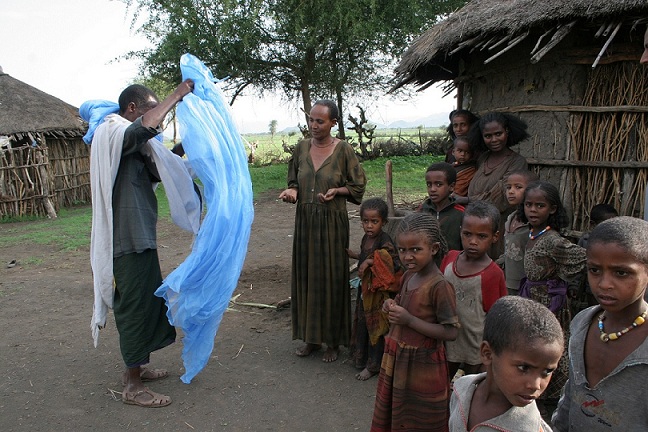 A man educates a community in Ethiopia on the uses of insecticide treated nets (ITNs).